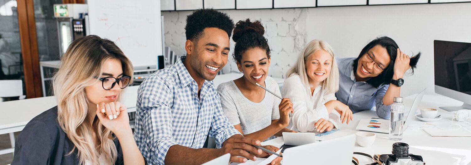 Groupe de jeunes adultes en plein travail sur leurs projets artistiques personnels, ambiance conviviale et entraide à l'Atelier Adya, quartier Bois Raguenet à Orvault.
